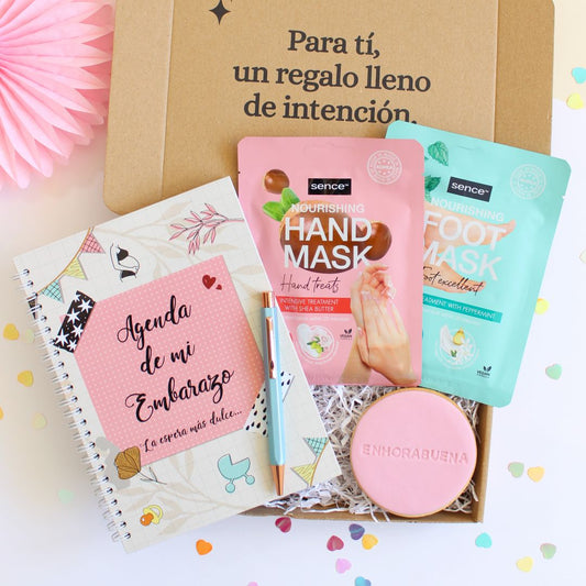Caja regalo treat box para mujer embarazada que incluye la agenda de mi embarazo, mascarillas nutritivas para pies y manos, bolígrafo hexagonal de color azul cielo y galleta de mantequilla redonda con la palabra enhorabuena impresa