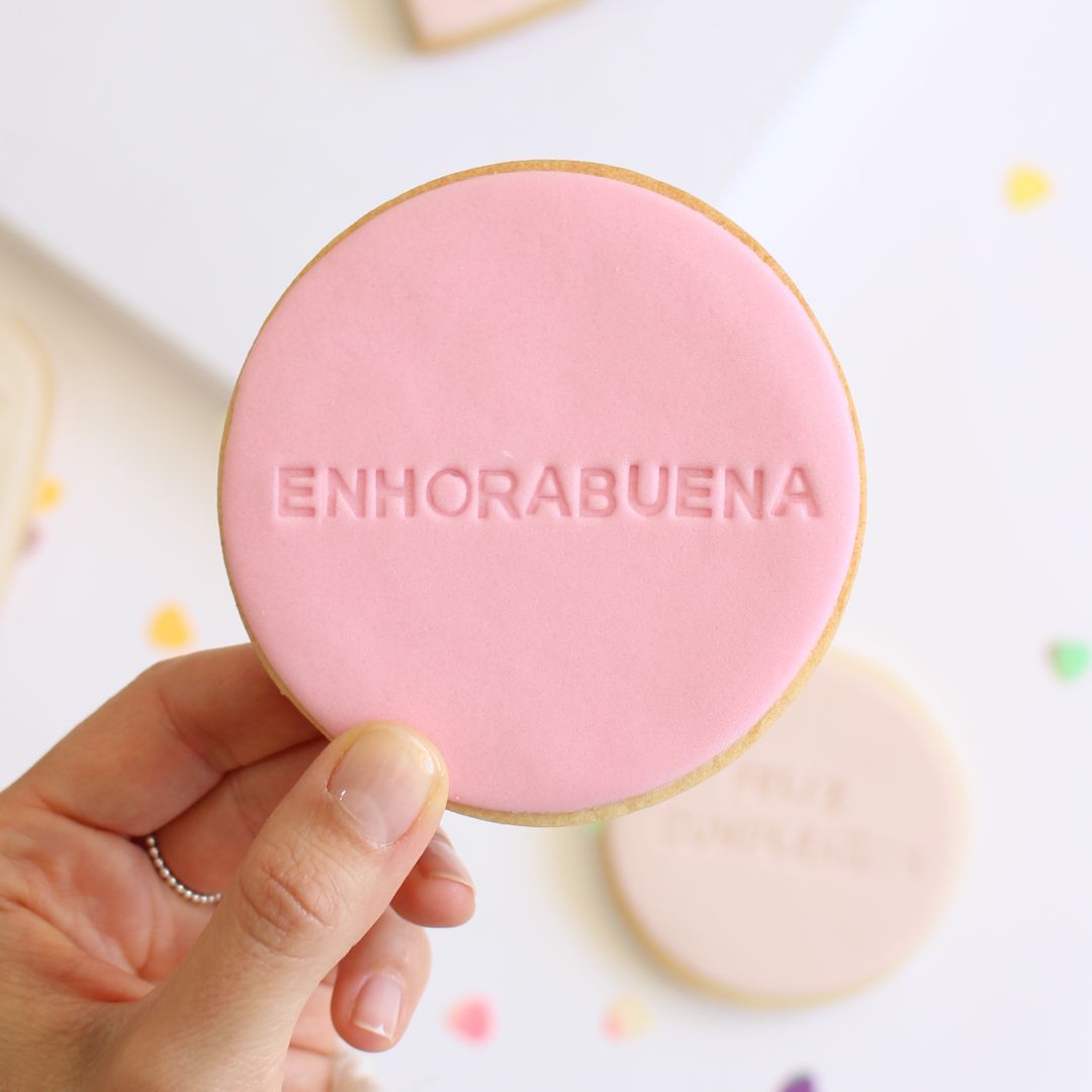 Galleta de mantequilla de forma redonda con la palabra enhorabuena impresa