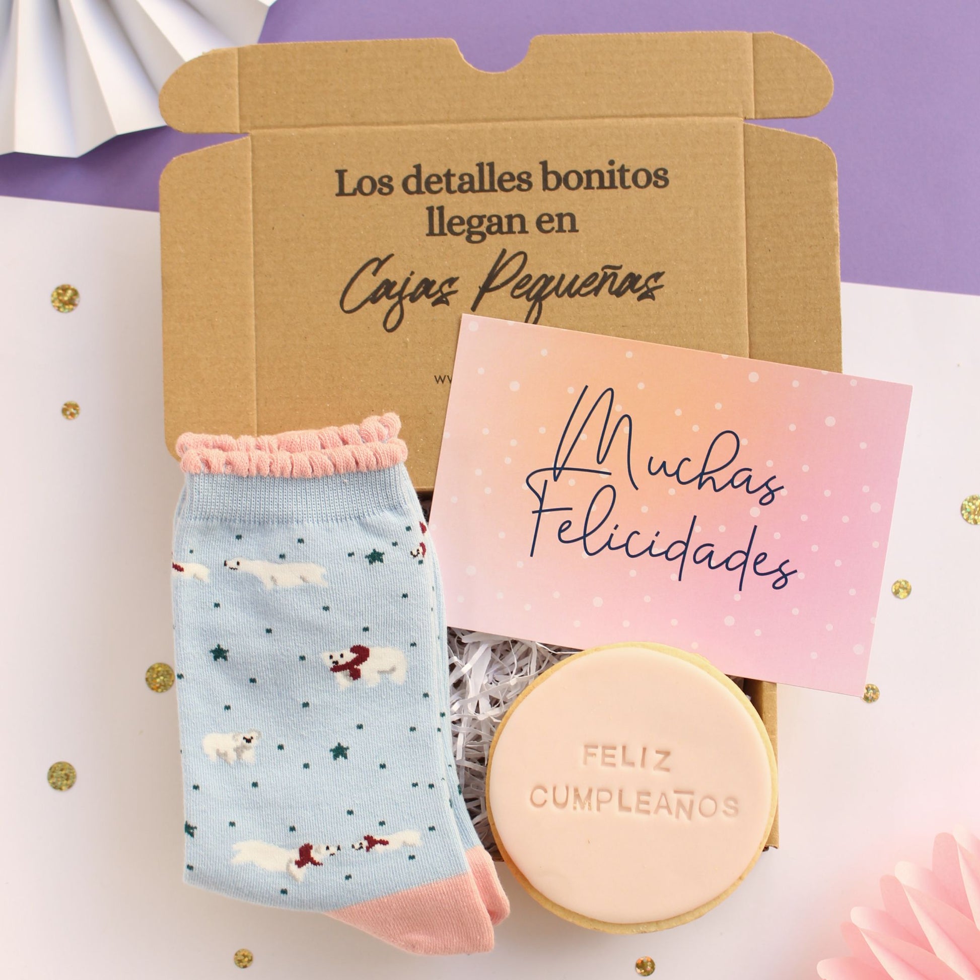 Mini caja regalo treat box para mujer con calcetines azul y rosa con diseño de osos polares, galleta de mantequilla color rosa pálido y leyenda feliz cumpleaños, y tarjeta de felicitación con texto muchas felicidades