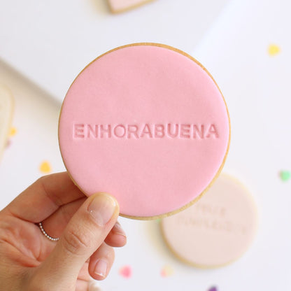 Galleta de mantequilla de forma redonda con la palabra enhorabuena impresa